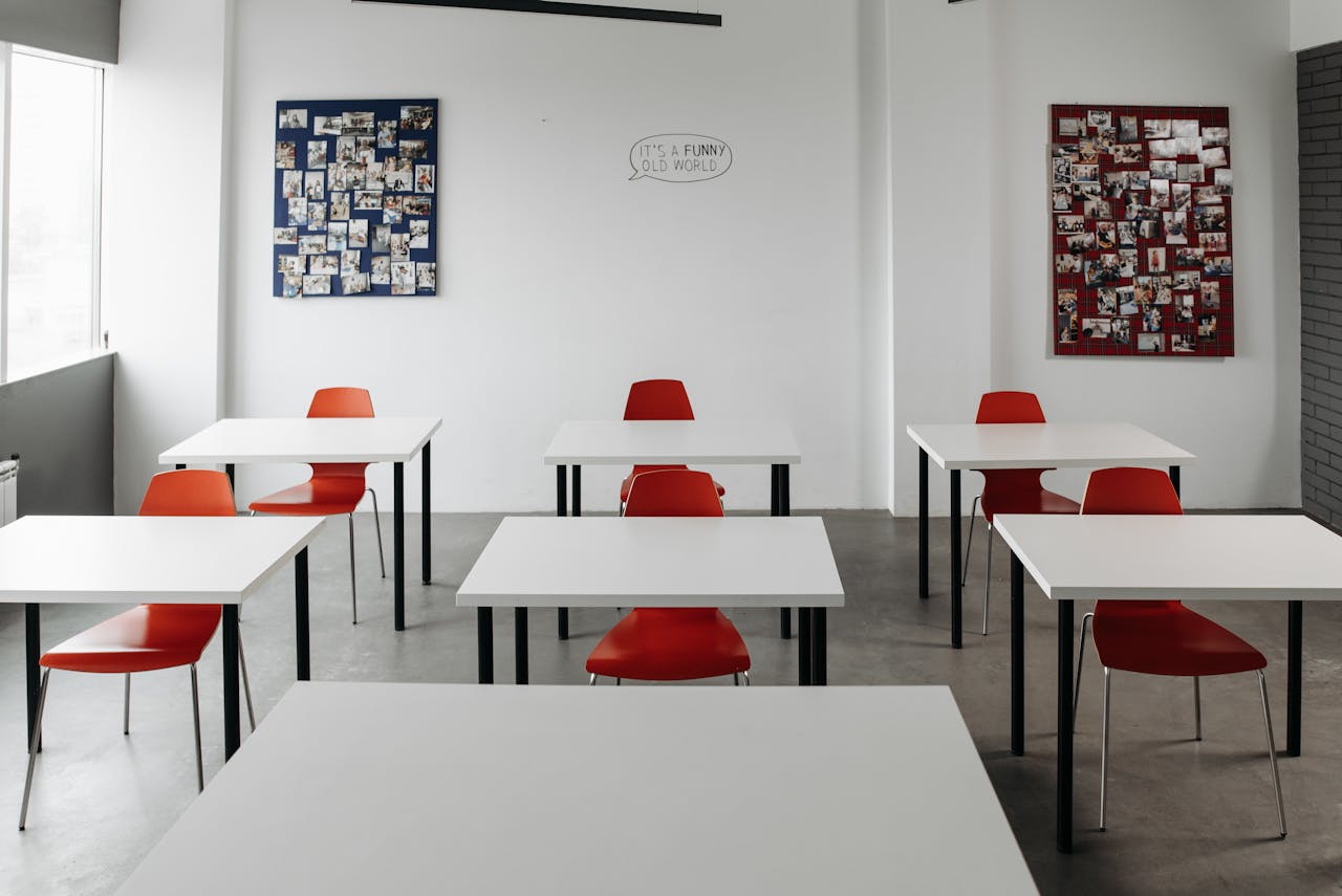 Spacious modern classroom featuring red chairs and white desks, ideal for education themes.